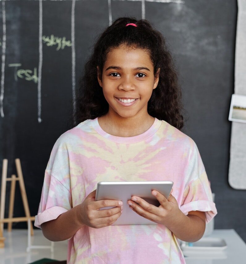 A girl is smiling with tablet in hand